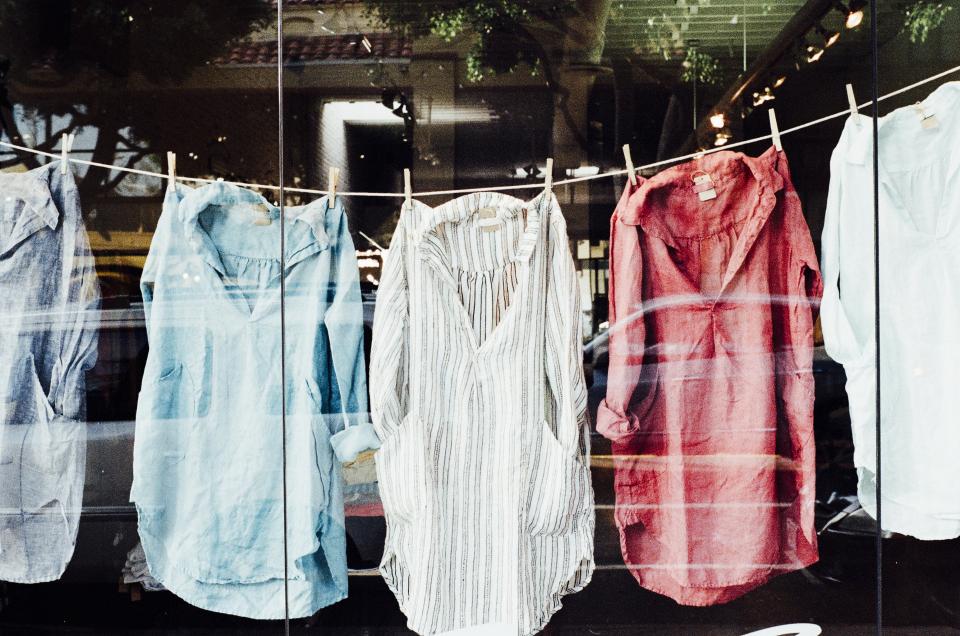 Camisas de colores secándose colgadas de una cuerda de tendedero al sol